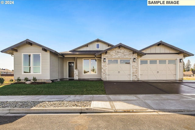 craftsman house featuring a front lawn and a garage