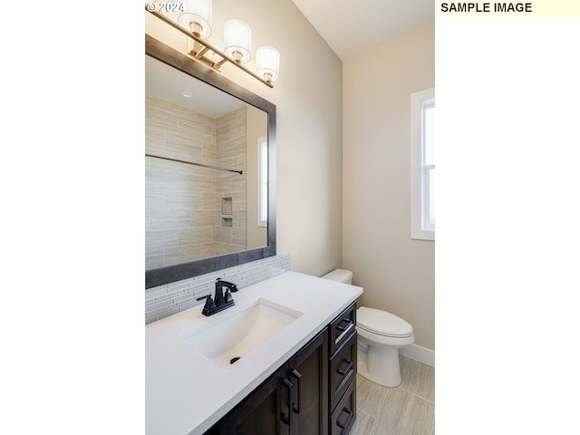 bathroom with toilet, tile flooring, and vanity