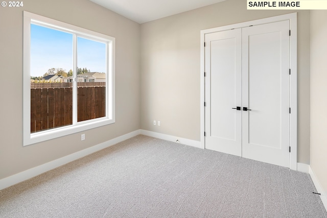 unfurnished bedroom with a closet and light carpet