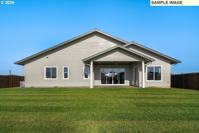 rear view of property featuring central AC, ceiling fan, and a yard