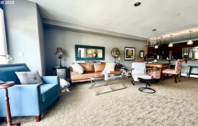 living room with carpet flooring, a notable chandelier, and sink