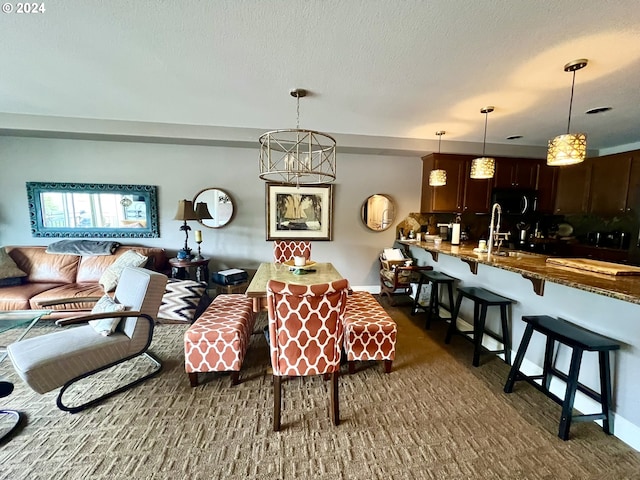 dining area with a textured ceiling, a notable chandelier, and sink