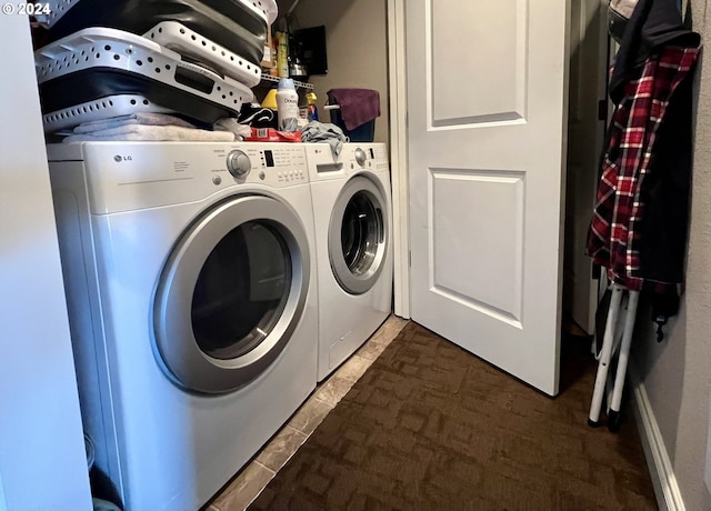 clothes washing area with dark colored carpet and washing machine and clothes dryer