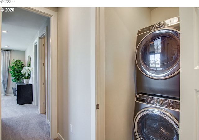 washroom with stacked washer / dryer and light carpet