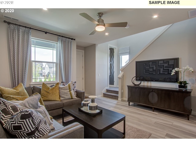 living room featuring ceiling fan and light hardwood / wood-style floors