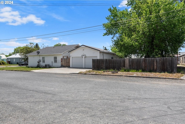 single story home with a garage and central air condition unit