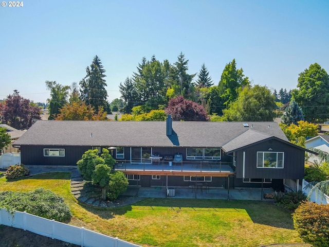 back of house featuring a lawn, a deck, central air condition unit, and a patio