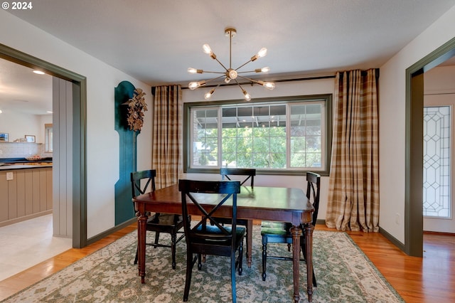 dining area with a chandelier, a textured ceiling, and light hardwood / wood-style flooring