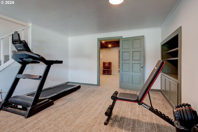 exercise room with light carpet and crown molding