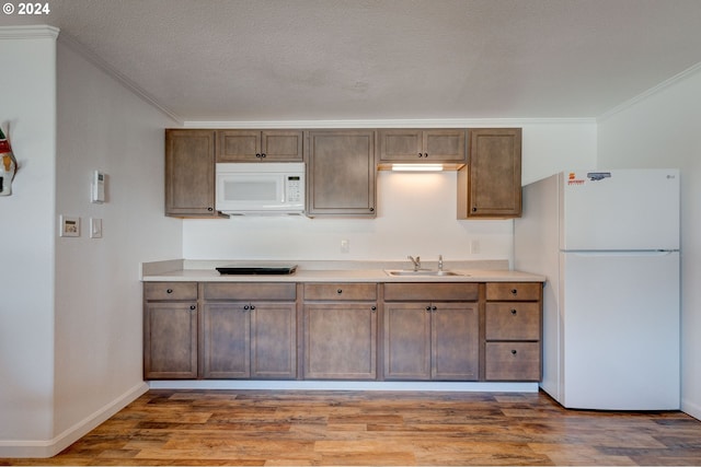 kitchen featuring hardwood / wood-style flooring, white appliances, sink, and ornamental molding