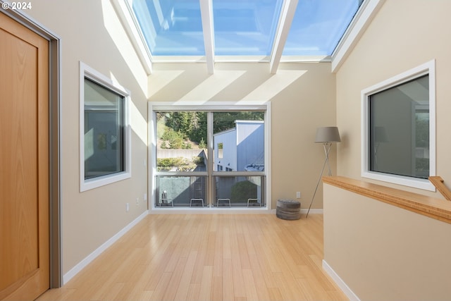 interior space with vaulted ceiling with skylight