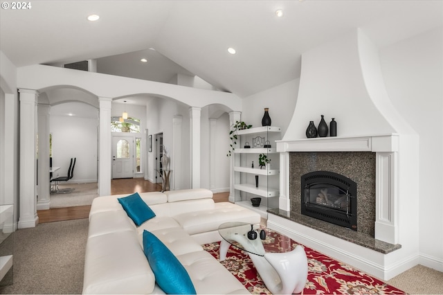 carpeted living room with a fireplace and high vaulted ceiling