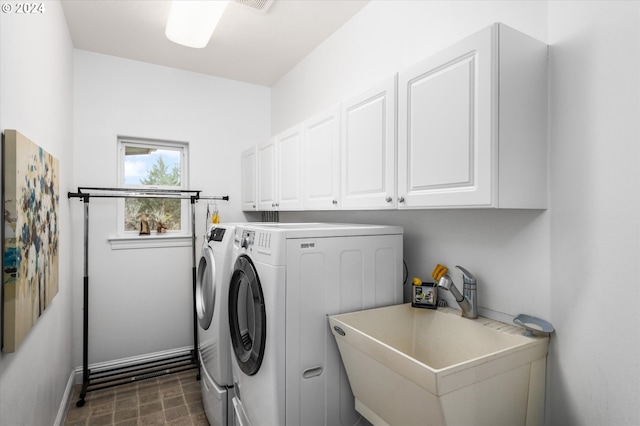 clothes washing area featuring sink, cabinets, and independent washer and dryer