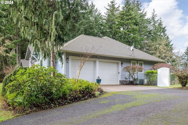 view of property exterior featuring a garage and central AC