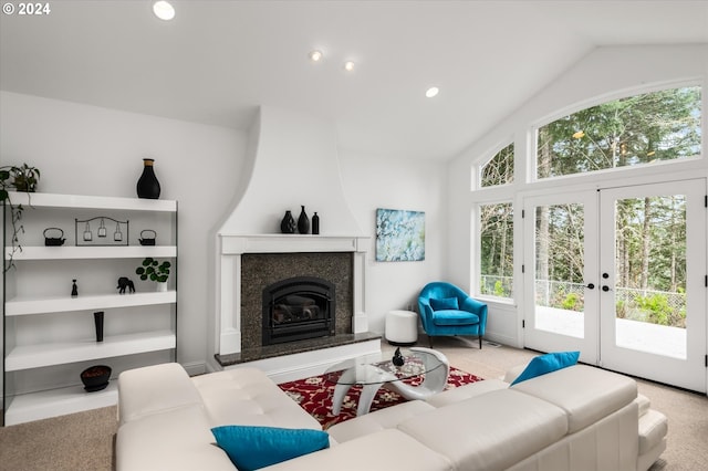 carpeted living room with french doors, a fireplace, and vaulted ceiling