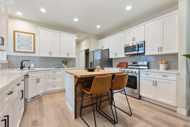 kitchen featuring sink, white cabinetry, appliances with stainless steel finishes, and light wood-type flooring