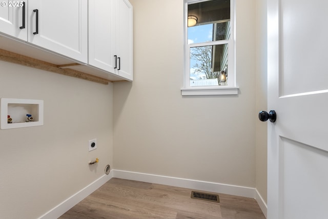 laundry room featuring washer hookup, cabinets, light hardwood / wood-style floors, and electric dryer hookup