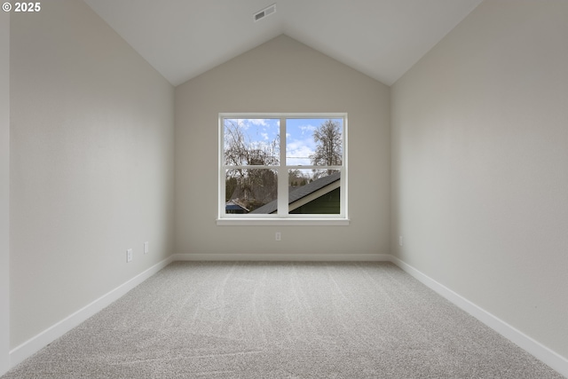 spare room with lofted ceiling and carpet flooring