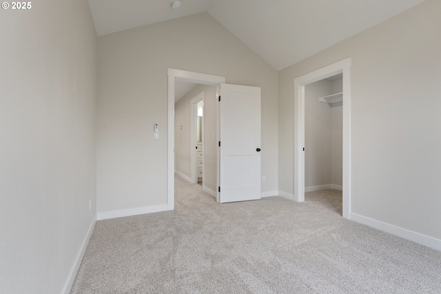 unfurnished bedroom with light colored carpet, a closet, and vaulted ceiling