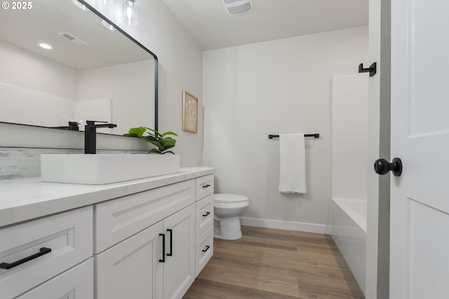 full bathroom with toilet, shower / bathtub combination, wood-type flooring, and vanity