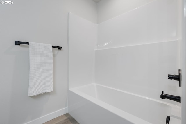 bathroom with a tub to relax in and hardwood / wood-style flooring