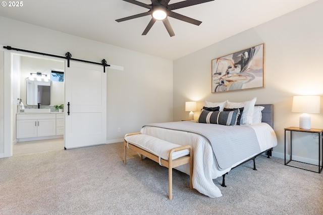 carpeted bedroom with ceiling fan, ensuite bathroom, a barn door, and sink