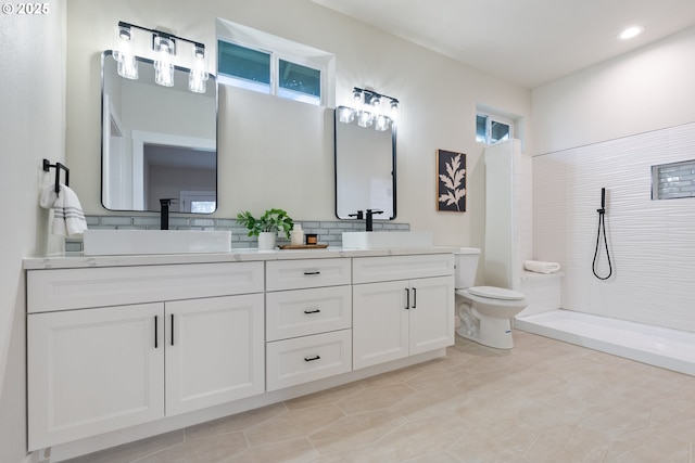 bathroom featuring tile patterned flooring, vanity, tasteful backsplash, toilet, and tiled shower