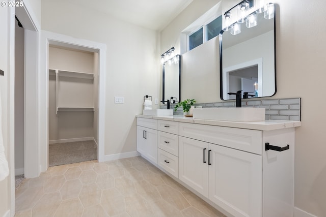 bathroom featuring tile patterned flooring, tasteful backsplash, and vanity