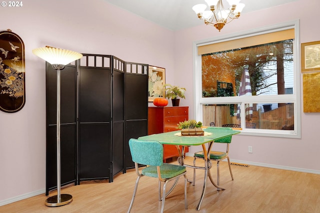 dining space featuring hardwood / wood-style flooring and a chandelier