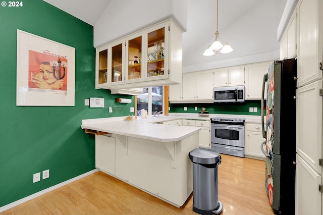 kitchen featuring stainless steel appliances, white cabinets, pendant lighting, and lofted ceiling