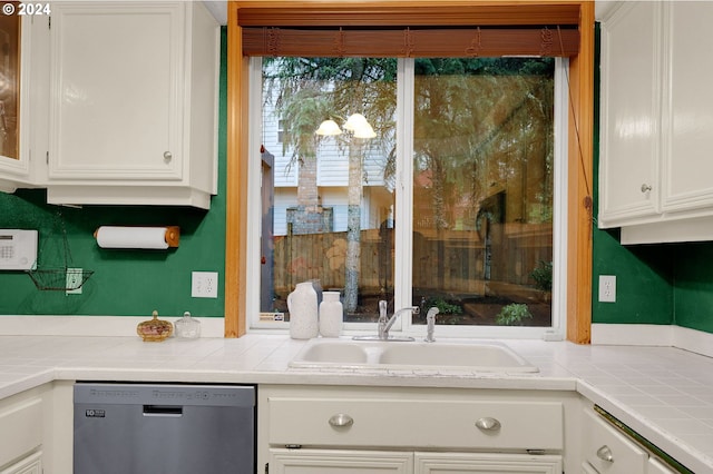 kitchen with dishwasher, tile countertops, white cabinetry, and sink