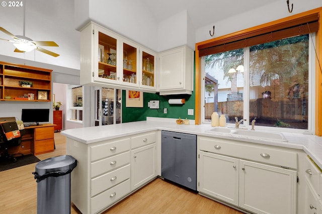 kitchen with dishwasher, sink, kitchen peninsula, white cabinets, and light wood-type flooring