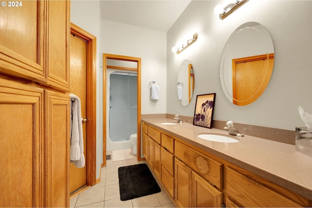 bathroom with tile patterned flooring, vanity, and walk in shower