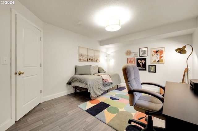 bedroom with light hardwood / wood-style flooring and a textured ceiling