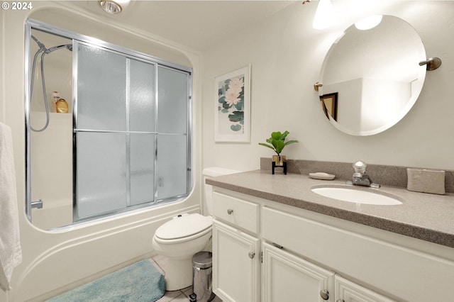 full bathroom with tile patterned floors, vanity, toilet, and bath / shower combo with glass door