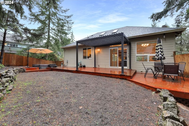 back of house featuring a wooden deck and a hot tub