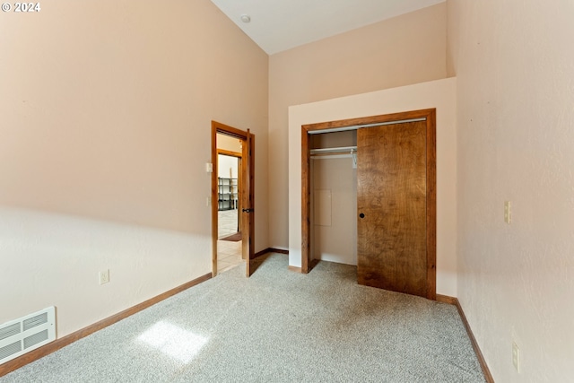 unfurnished bedroom featuring baseboards, a closet, visible vents, and light colored carpet