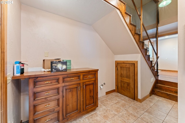 interior space with tile patterned flooring, baseboards, and vaulted ceiling