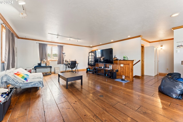 living room featuring a textured ceiling, ornamental molding, hardwood / wood-style flooring, and baseboards