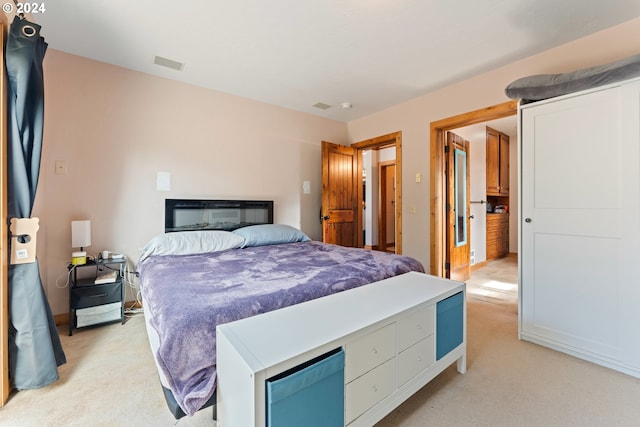 bedroom featuring visible vents and light colored carpet