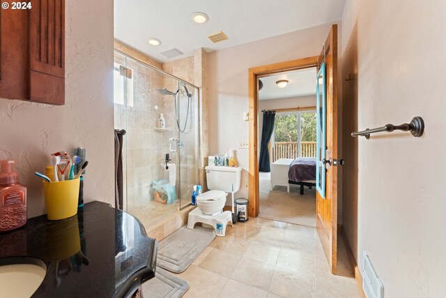 bathroom with tile patterned floors, vanity, a shower with door, and toilet