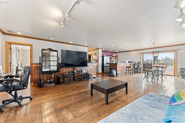 living area featuring ornamental molding, hardwood / wood-style floors, recessed lighting, and track lighting