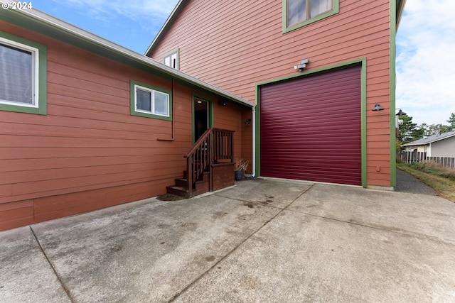 view of side of home featuring a garage and concrete driveway