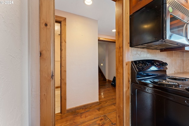 kitchen featuring tasteful backsplash, baseboards, black electric range oven, wood finished floors, and recessed lighting