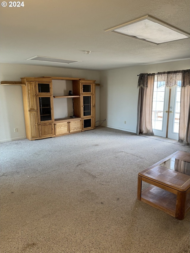 unfurnished living room with carpet flooring and french doors