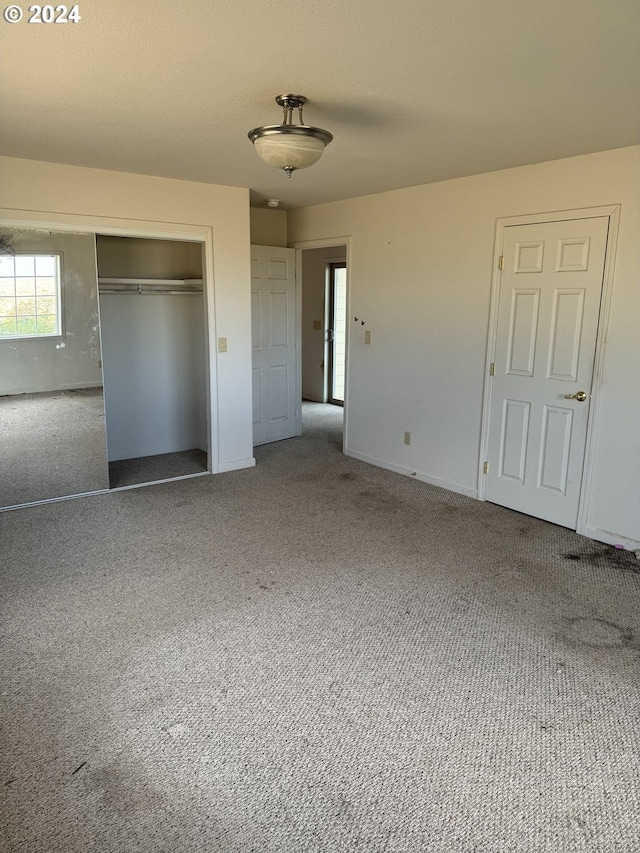 unfurnished bedroom with carpet flooring and a closet