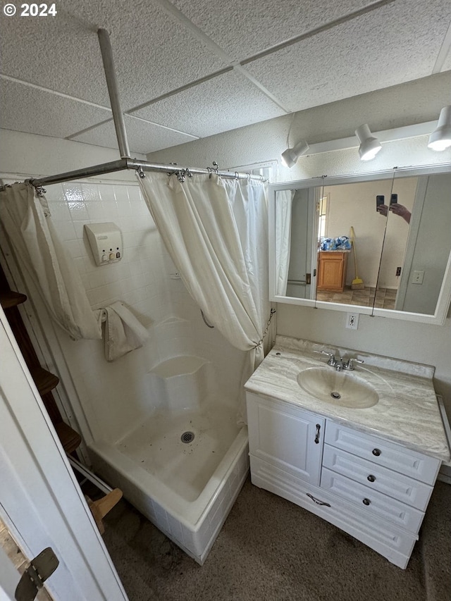 bathroom with a shower with shower curtain, a drop ceiling, and vanity