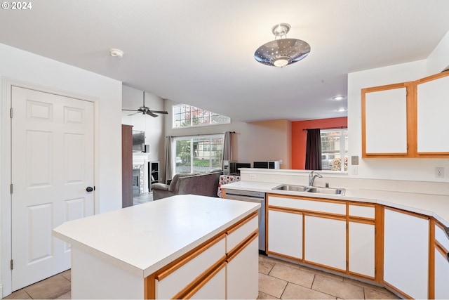 kitchen featuring dishwasher, white cabinets, sink, ceiling fan, and light tile patterned floors