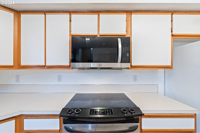 kitchen featuring electric range and white cabinetry