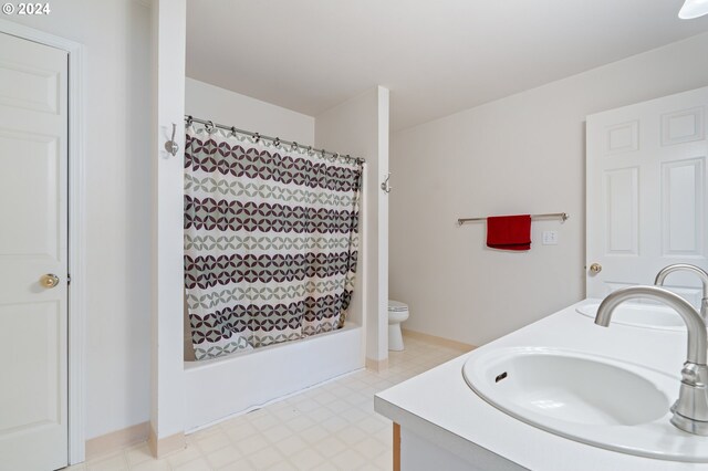 full bathroom featuring shower / bath combo with shower curtain, vanity, and toilet